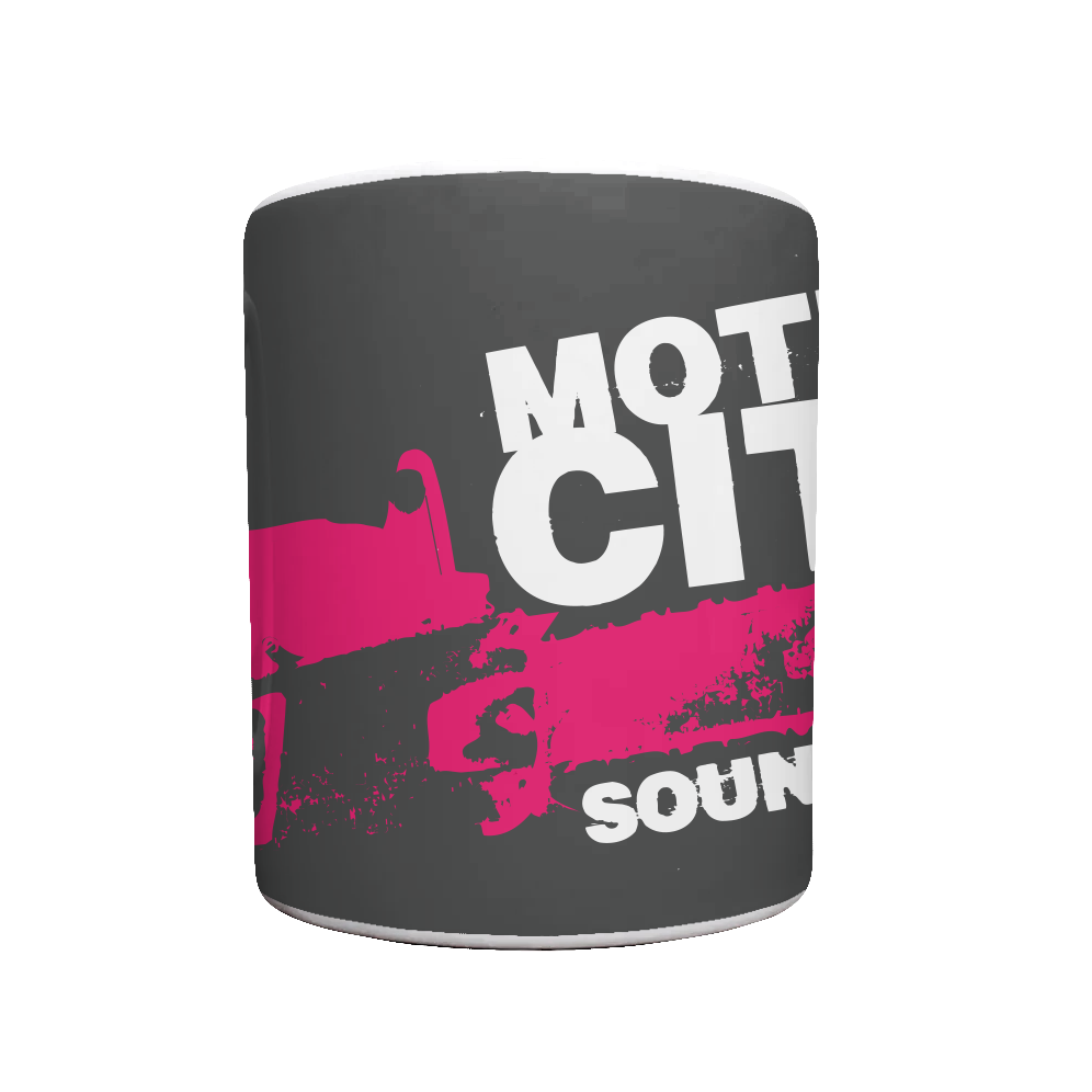 White mug with black background, MOTION CITY SOUNDTRACK in bold white lettering, pink chainsaw graphic.