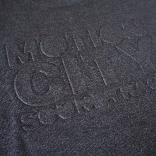 Dark grey crewneck with MOTION CITY SOUNDTRACK in embossed lettering on the chest